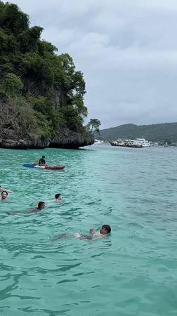 Morning swimmers and kayakers enjoy Haad Hin Khom waters