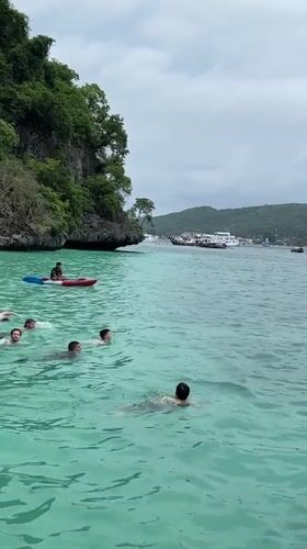 Morning swimmers and kayakers enjoy Haad Hin Khom waters