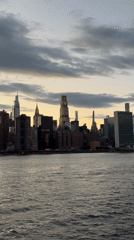 Nighttime skyline view captured across choppy East River