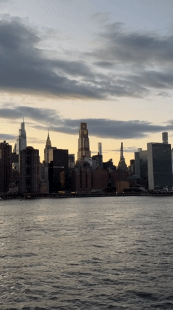 Nighttime skyline view captured across choppy East River