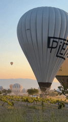 Hot air balloons rise over Cappadocia at sunrise