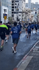 Marathon runners race through wet Tel Aviv streets Friday morning