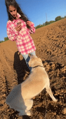 Woman photographs with dog in Bulgarian countryside field