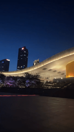 Red-lit skyscrapers illuminate Futian District plaza at night