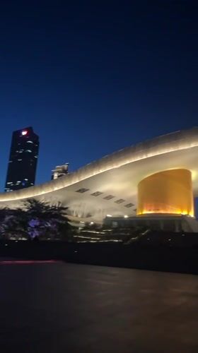 Red-lit skyscrapers illuminate Futian District plaza at night