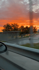 Vivid sunset sky rolling past a car window near Klaipėda