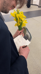 Artist sketches portrait while holding yellow flowers in Moscow