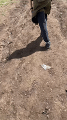 Person walks muddy path in rural Armenian mountain village