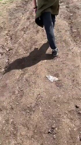 Person walks muddy path in rural Armenian mountain village