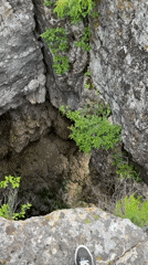 Person explores deep rocky crevice in outdoor terrain