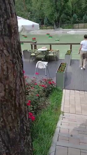 Almaty park in summer: flowers, waterside gazebo, outdoor dining