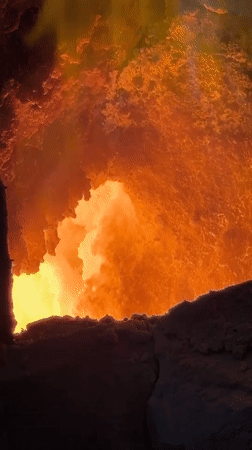 Worker documents molten furnace operations in Belarus industrial facility