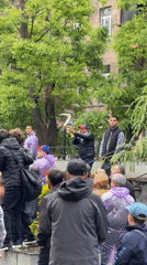 Crowd gathers in Yerevan park during rainy afternoon