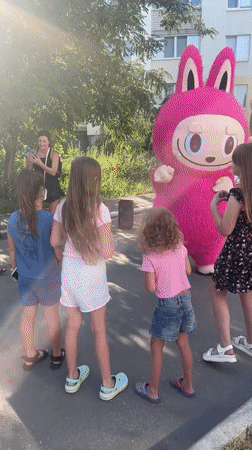 Pink bunny mascot meets a crowd outside Saratov apartment block