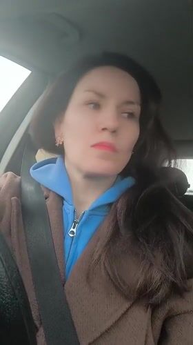 Woman in car, vintage scooter display captured in Riga