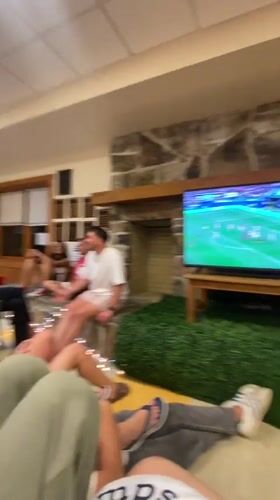 Young adults watch soccer game in cozy Washington Township room