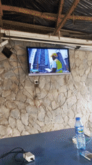 Outdoor TV displays construction worker on leadership news program