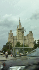 Vehicle passes historic Moscow embankment building on city street