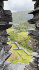 Tourist explores historic stone ruins and quarry landscapes in Llanberis