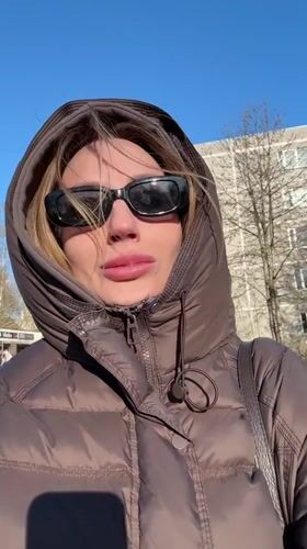 Woman films outdoor selfie video in sunny Riga