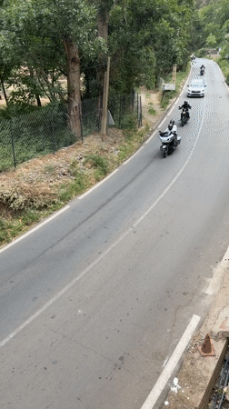 Motorcyclists travel paved road in Asgaour, Morocco