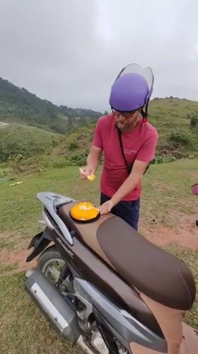Motorcyclist enjoys yellow dessert on Vietnamese hillside