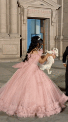 Woman in princess gown poses with dog outside Santa building