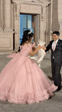 Woman in princess gown poses with dog outside Santa building