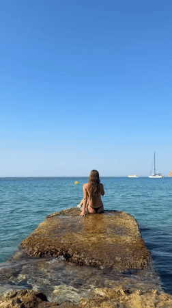 Perched on coastal rocks off Andratx, clear blue Mediterranean ahead.
