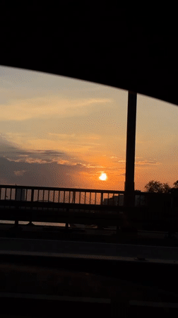 Golden sunset over Riga, framed through a moving car window