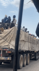 Passengers ride atop semi-truck cargo bed in Lokoja