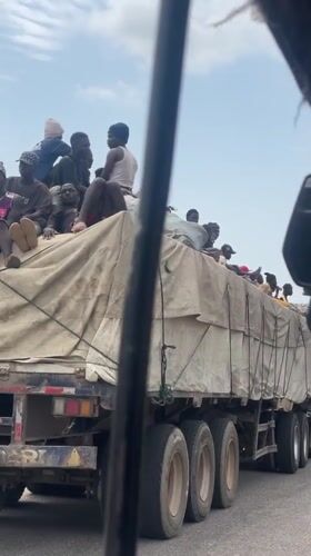 Passengers ride atop semi-truck cargo bed in Lokoja