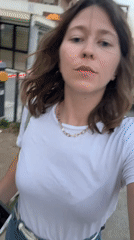 Woman films selfie video in Podgorica street during twilight