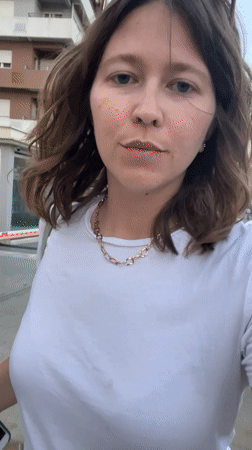 Woman films selfie video in Podgorica street during twilight