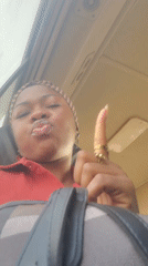 Woman in red shirt, headscarf photographed in Kakau, Nigeria