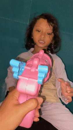 Girl plays with bubbles during morning playtime in Indonesia