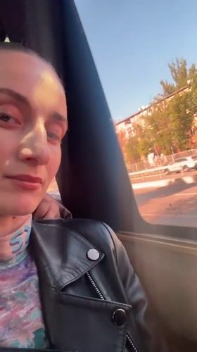 Woman gazes from vehicle window in Kryvyi Rih