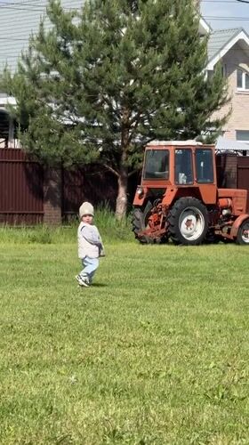 Toddler spotted on lawn with orange tractor in Vysokinichi
