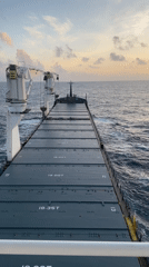 Freight ship observed on calm Atlantic waters during sunset