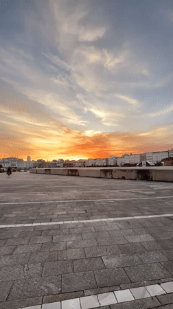 Vibrant sunset illuminates A Coruña cityscape, witnessed from multiple locations