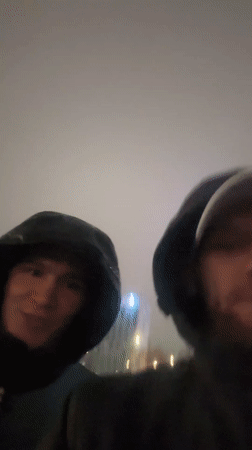 Two men filmed speaking on rainy Perm street
