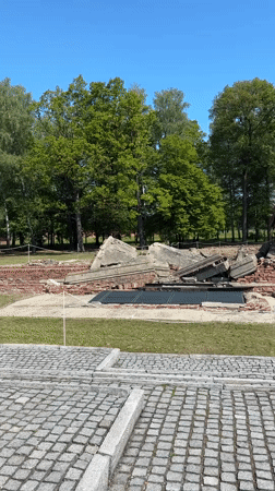 Visitor documents crematorium ruins at Brzezinka concentration camp site
