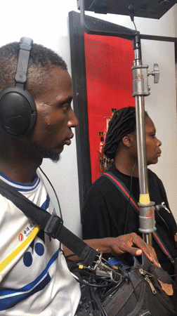 Film crew conducts indoor studio shoot with interview setup