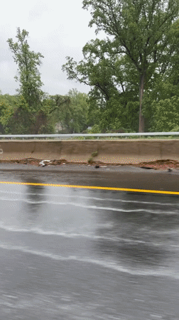 Yellow Corvette drives wet highway during rainy evening