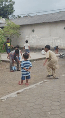 Kids playing soccer in a dirt yard, Tegalsari, Indonesia