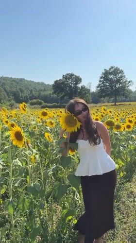 Posing among sunflowers in rural Tuscany, July afternoon