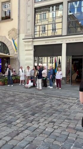 Street musicians perform near outdoor cafe in Lviv