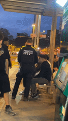 Police officer speaks with young man at Barcelona transit stop