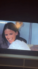 Evening home moments: TV viewing, flower photo, cat footage captured