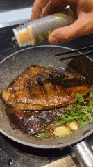 Steak seasoning in progress on a Milan stovetop